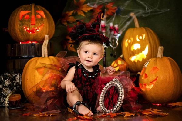 Małe dziecko Dziewczyna Czarownica śmiechu wśród dynie i świece. — Zdjęcie stockowe