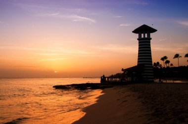 Karayip Denizi'nin kıyısında çizgili kırmızı beyaz feneri. Dominik Cumhuriyeti.