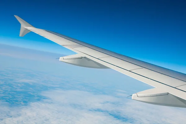 The wing of an airplane in the sky above the clouds. — Stock Photo, Image