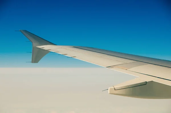 The wing of an airplane in the sky above the clouds. — Stock Photo, Image