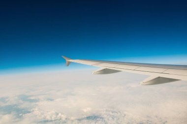 Bir uçak bulutların üzerinde gökyüzünde kanat.