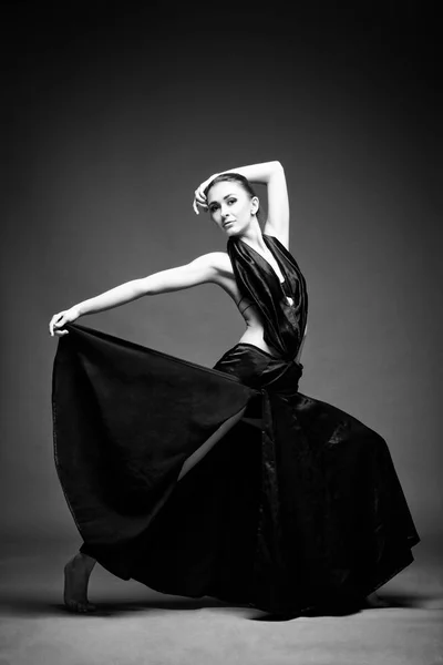 Ein schönes athletisches Mädchen in einem schwarzen Kleid tanzt — Stockfoto