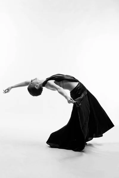 一个漂亮的运动女孩穿着黑色的连衣裙跳舞 — 图库照片