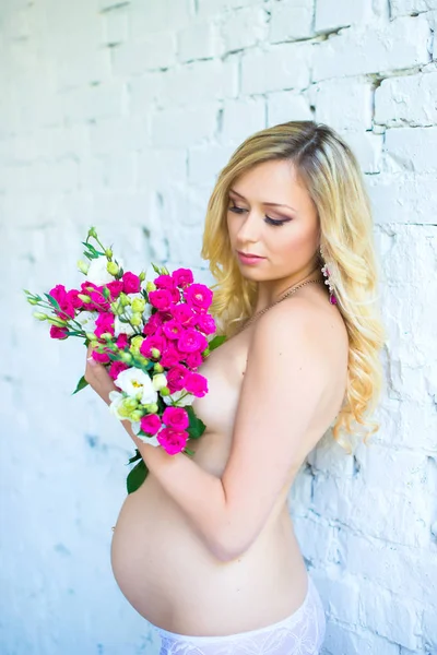 Bir buket çiçek bebek için bekleyen ile güzel hamile bayan. Gebelik.