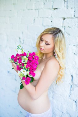 Bir buket çiçek bebek için bekleyen ile güzel hamile bayan. Gebelik.