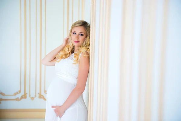 Gravidez em um vestido de renda branca. À espera do bebé. . — Fotografia de Stock