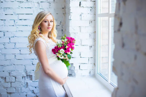Piękna Pani w ciąży z bukietem kwiatów, czekając na dziecko. Ciąża. — Zdjęcie stockowe