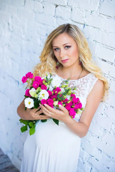 Beautiful pregnant lady with a bouquet of flowers waiting for the baby. Pregnancy. — Stock Photo, Image