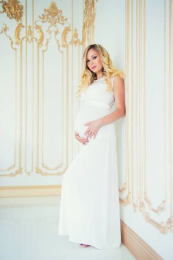 Beyaz dantel elbise gebelikte. Bebek bekliyor.