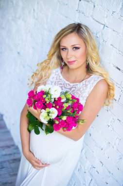 Bir buket çiçek bebek için bekleyen ile güzel hamile bayan. Gebelik.