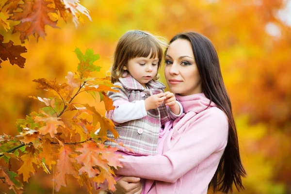 Menina e sua mãe brincando no parque de outono — Fotografia de Stock