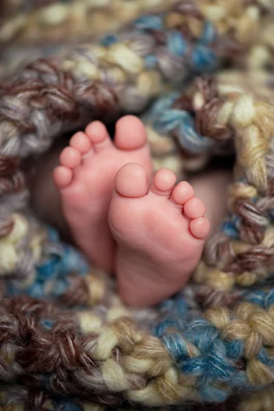 Pequeno bebê pernas em um cachecol cinza — Fotografia de Stock