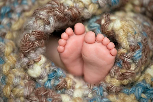 Μωράκι τα πόδια σε ένα γκρίζο κασκόλ — Φωτογραφία Αρχείου