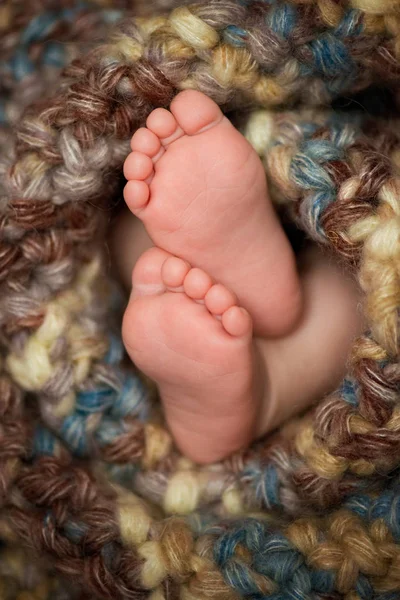 Μωράκι τα πόδια σε ένα γκρίζο κασκόλ — Φωτογραφία Αρχείου