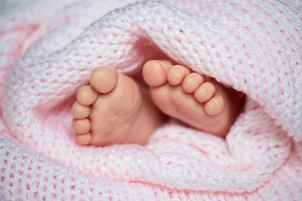 Malé dítě nohy v šedá šála — Stock fotografie