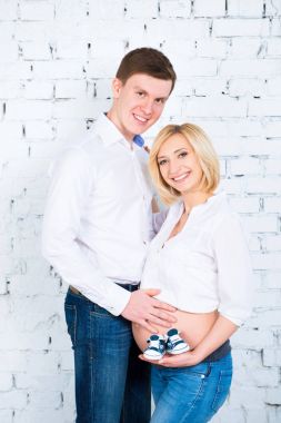 Arka plan hamile bir kadın oryantal bir genç Baba elinde çocuk ayakkabı