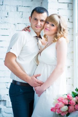 Güzel bir çift, hamile bir kadın ve bir adam bir pencere stand, bir kalp elinde yüzüstü yapmak.