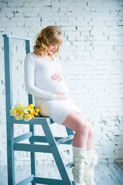 Beyaz Lale bir buket ile beyaz bir elbise genç güzel bir hamile kadın — Stok fotoğraf