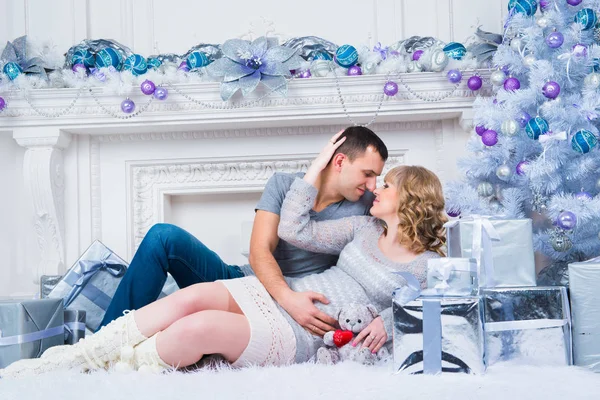 Těhotenství a Vánoce, mladý pár čekající na pozadí vánoční stromeček — Stock fotografie