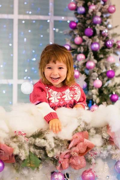 Menina feliz brincando com bolas de neve no quarto. A menina lança uma bola de neve . — Fotografia de Stock