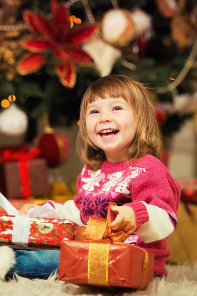 Szczęśliwa dziewczyna z dar w rękach na tle drzewa nowy rok. — Zdjęcie stockowe
