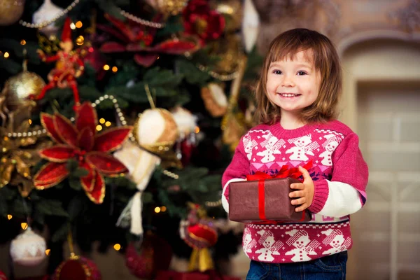 La muchacha feliz con el regalo en las manos sobre el fondo del árbol de Año Nuevo . —  Fotos de Stock