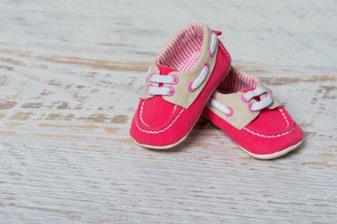 Bebeğim kırmızı ayakkabılar beyaz duvara karşı bir ip üzerinde.