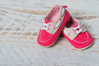 Bebeğim kırmızı ayakkabılar beyaz duvara karşı bir ip üzerinde.