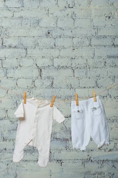 Beyaz duvara karşı bir ip üzerinde çocuk beyaz beden ve külotlu çorap Makinası. — Stok fotoğraf