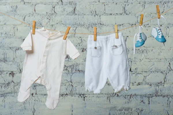 Beyaz duvara karşı bir ip üzerinde çocuk beyaz vücut, çizme ve külotlu çorap Makinası. — Stok fotoğraf