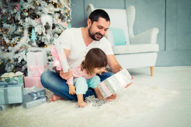 Büyük baba ve mutlu küçük kız yeni yıl hediyeleri Noel ağacı yakınındaki açın