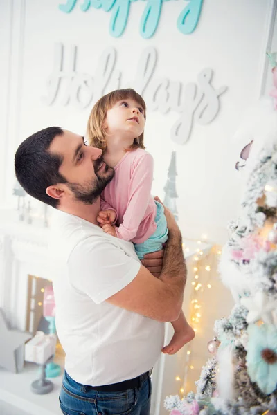 Kleine Tochter und Vater beim Weihnachtsbaum. frohes neues Jahr — Stockfoto