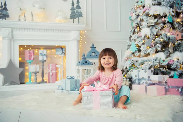 아기 소녀 크리스마스 트리 근처 새 해 선물을 엽니다. — 스톡 사진