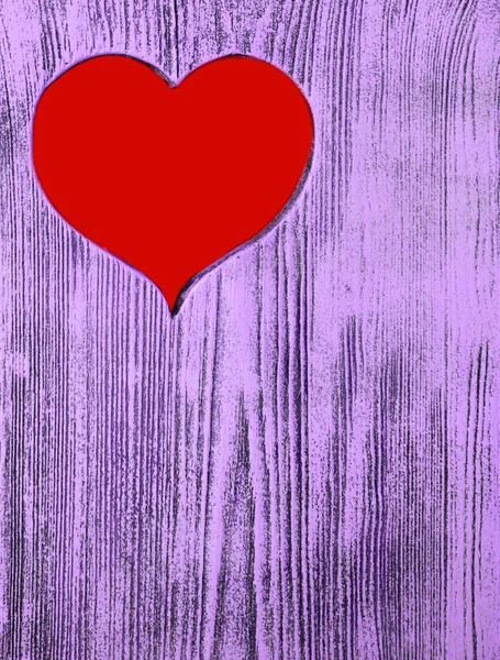 Il cuore rosso è scolpito in una tavola di legno di viola. Contesto . — Foto Stock