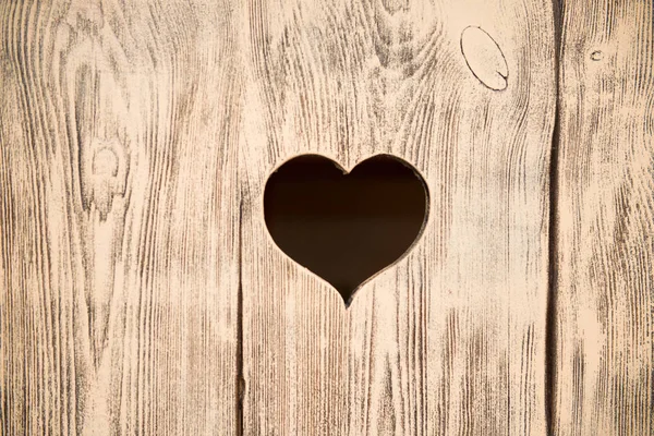 Corazón tallado en una tabla de madera. Contexto . — Foto de Stock