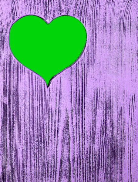 The green heart is carved in a wooden board of purple. Background