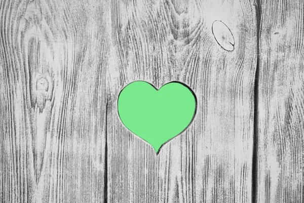 The green heart carved in a wooden board. Background