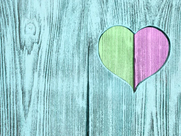 Grüne und rosa Herzen in ein Holzbrett geschnitzt. Hintergrund. Postkarte, Valentinstag. — Stockfoto