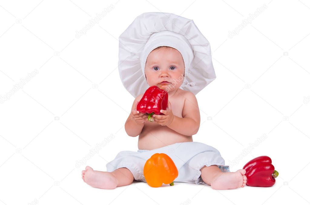 A funny little girl in a chef's clothes is eating pepper