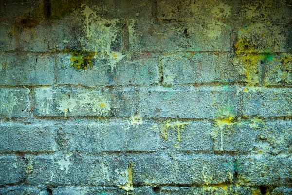 Fundo e papel de parede ou textura de uma parede de tijolo azul com manchas de tinta amarela . — Fotografia de Stock