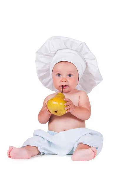 Criança alegre com uma pêra nas mãos em um terno de chef em um fundo branco . — Fotografia de Stock