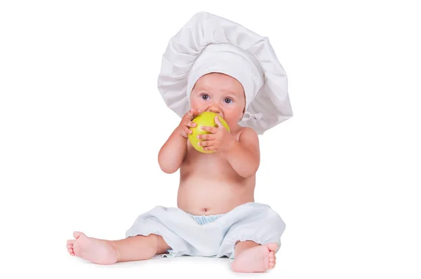 Веселый маленький ребенок с яблоками в руках в костюме шеф-повара на белом фоне . — стоковое фото