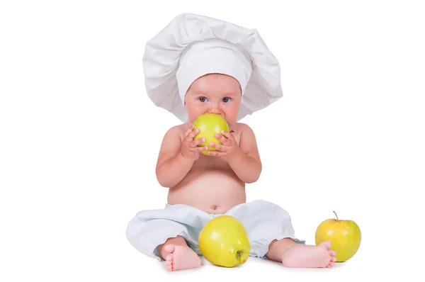 Petit enfant joyeux avec des pommes dans les mains dans un costume de chef sur un fond blanc . — Photo