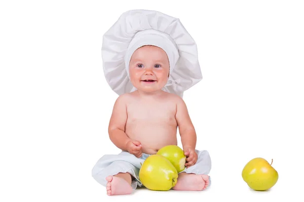 Niño alegre con manzanas en las manos en un traje de chef sobre un fondo blanco . —  Fotos de Stock