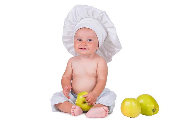 Petit enfant joyeux avec des pommes dans les mains dans un costume de chef sur un fond blanc . — Photo