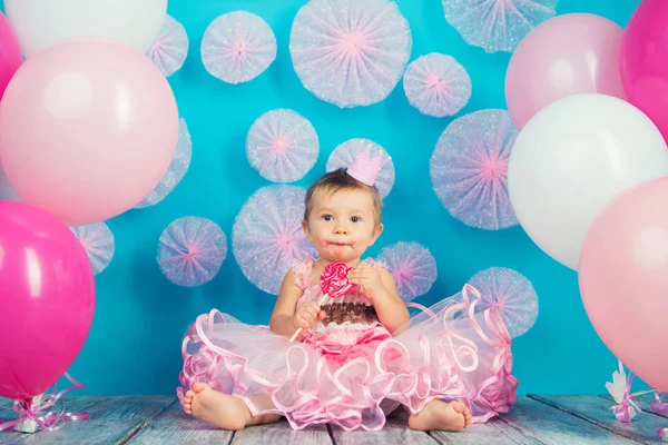 Criança engraçada com um pirulito na forma de um coração, menina feliz . — Fotografia de Stock