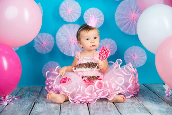 Criança engraçada com um pirulito na forma de um coração, menina feliz . — Fotografia de Stock