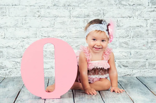 Vacker och söt tjej i en rosa klänning med bokstaven O. känslomässiga flicka. — Stockfoto