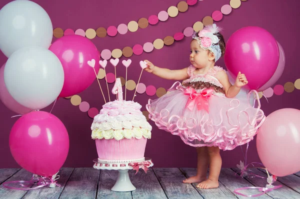 A aniversariante da menina foi enfiada num bolo. O primeiro bolo. O uso do primeiro bolo. Bolo de esmagamento . — Fotografia de Stock