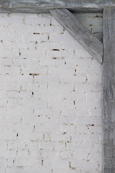 Vigas de madera gris contra una pared de ladrillo blanco . —  Fotos de Stock